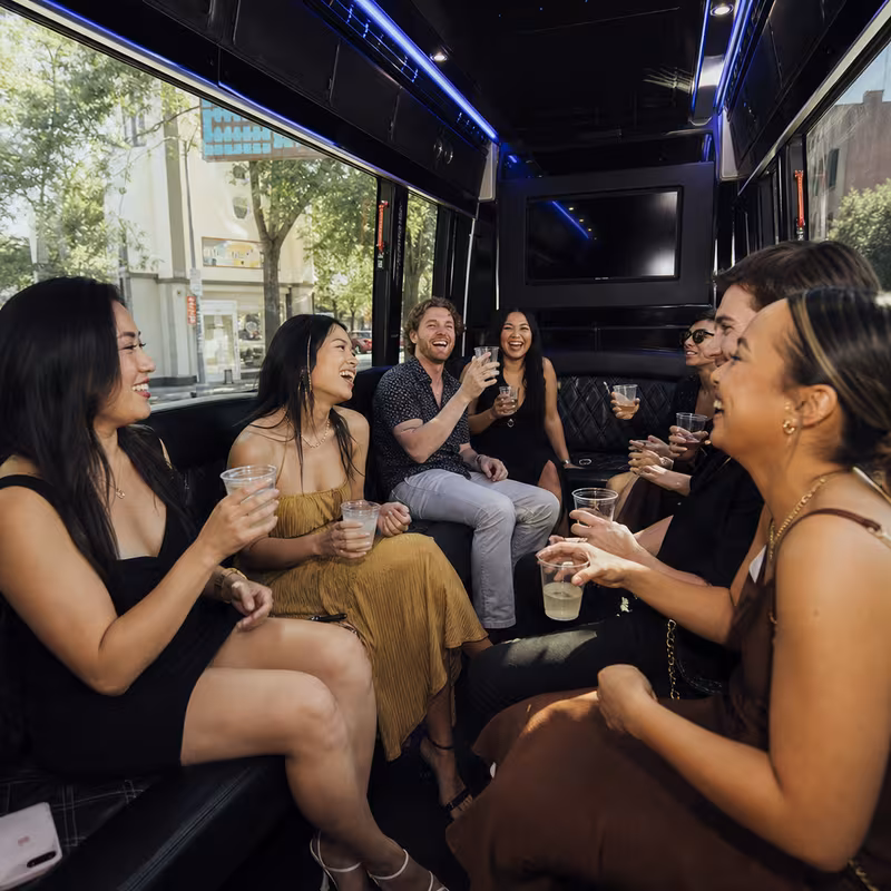 Party bus interior with wraparound leather seating and LED lighting in Stockton
