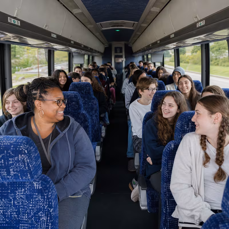 Group boarding a white charter bus for School Transportation transportation in Stockton