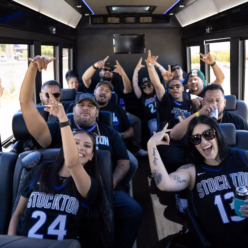 Group boarding a white charter bus for Sporting Event Transportation transportation in Stockton